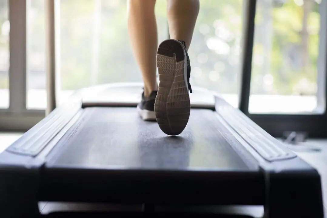 close up of woman runner shoes on running machine or treadmill in fitness gym, healthy and exercise activity concept.