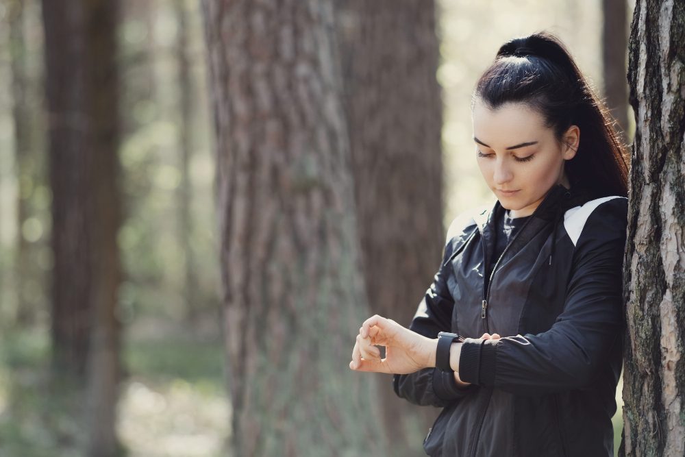 entete femme qui regarde sa montre sport rucking foret