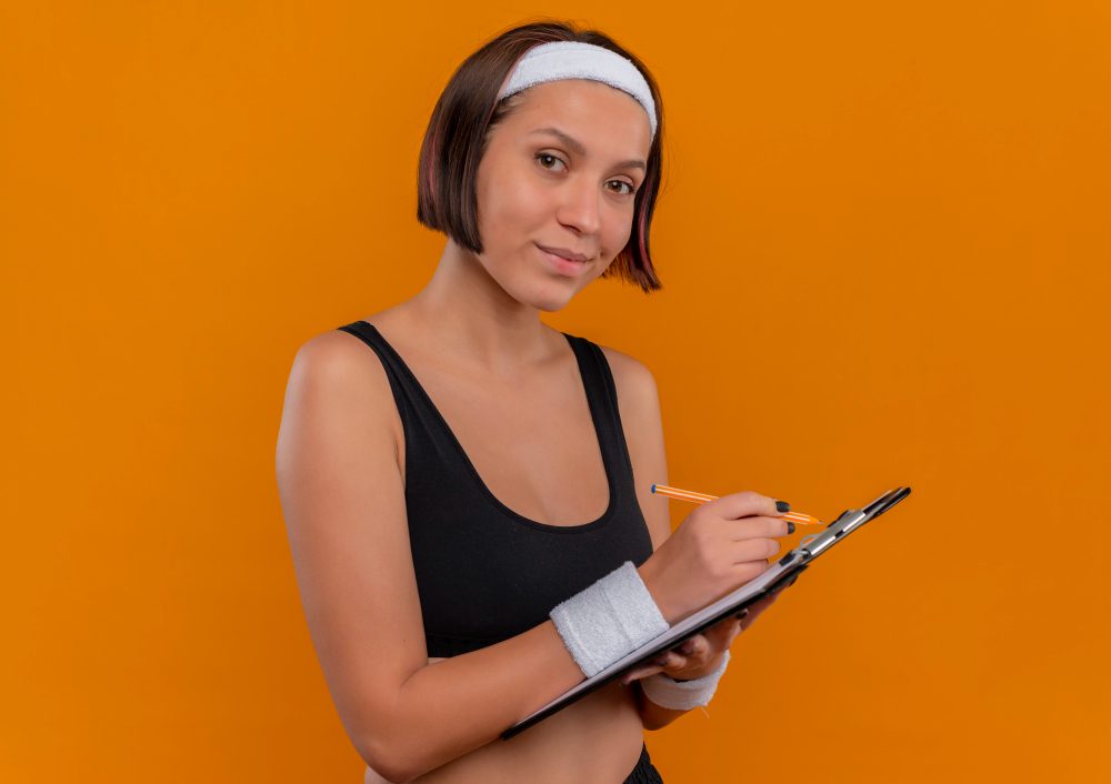 femme sportive note ses activités sur une feuille