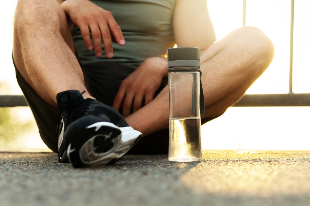 jogger sitting on the road after his outdoors running workout