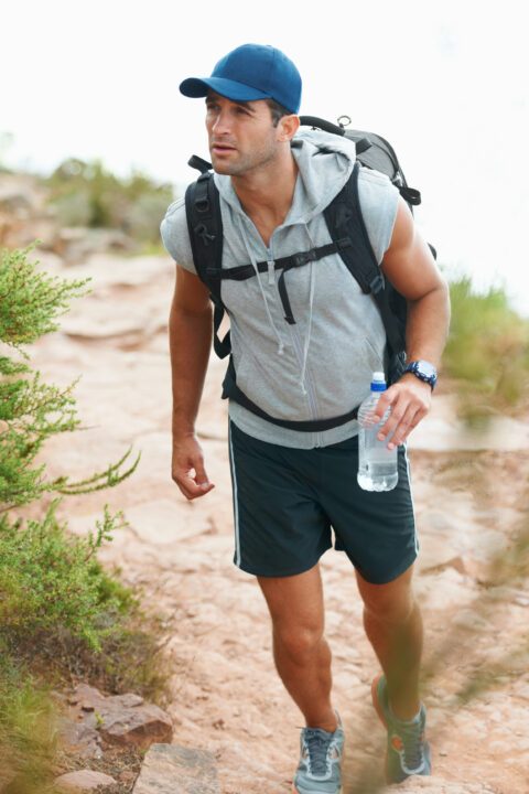 its important to keep hydrated. happy young hiker walking with a