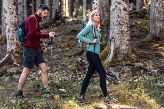 Deux randonneurs avec sac à dos marchant en regardant le paysage forestier