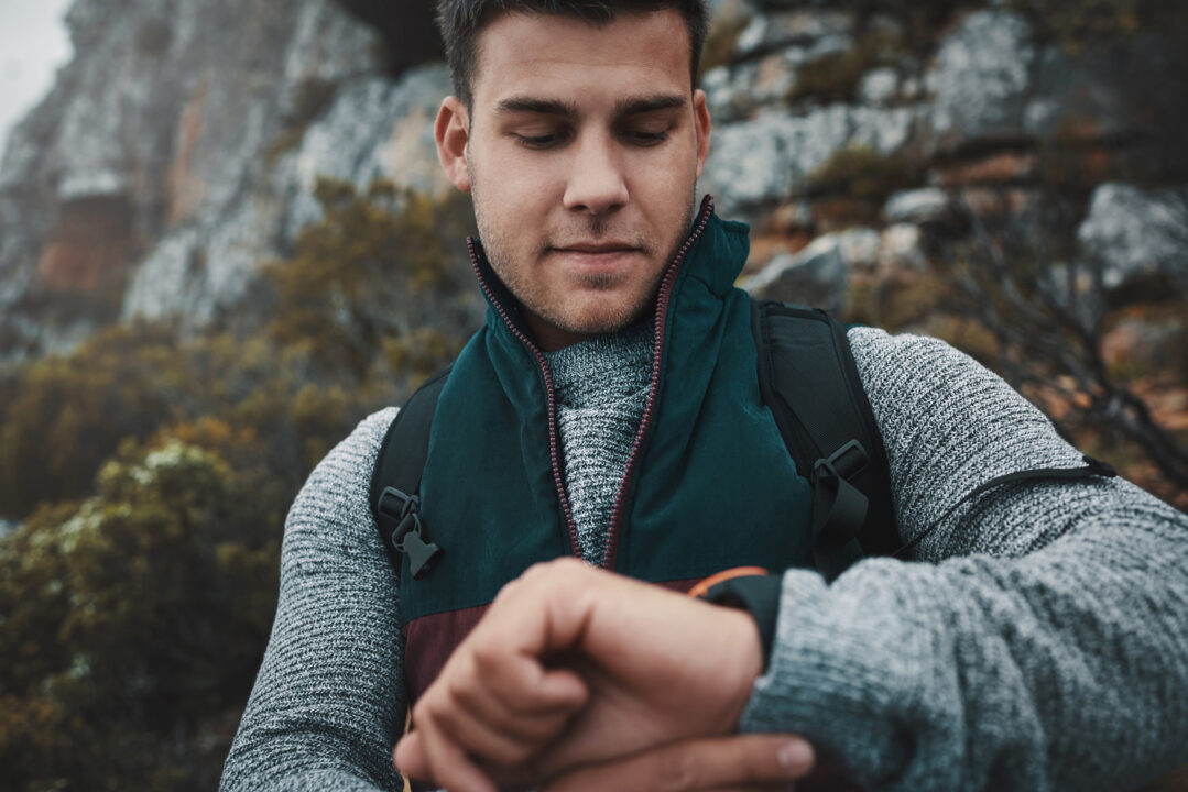 Homme en ruck dans la nature avec une montre connectée pour suivre son activité physique et son parcours