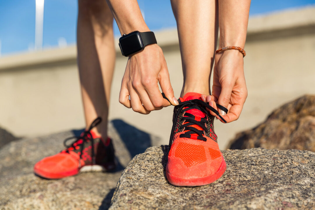 close up of a male runner tying his shoelaces