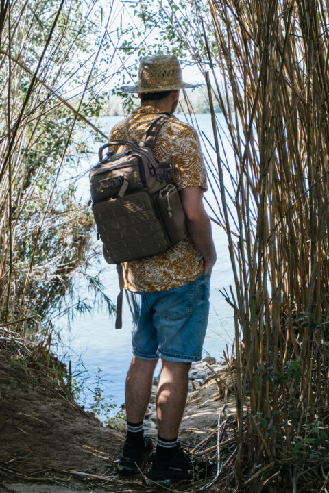 traveler in front of a river between vegetation