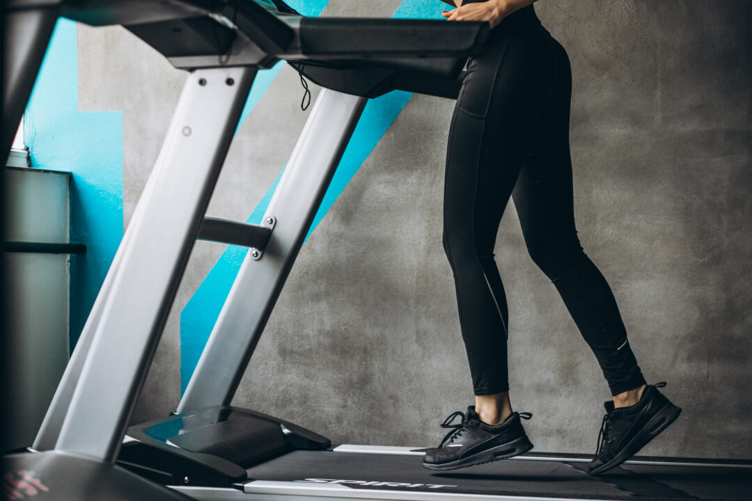 female legs on the running track at the gym