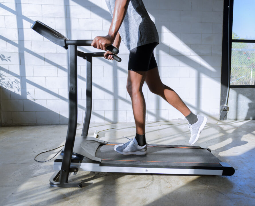 young man in sportswear running on treadmill at gym.