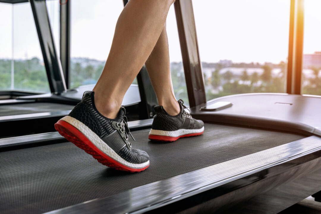 male feet in sneakers running on the treadmill at the gym. exerc